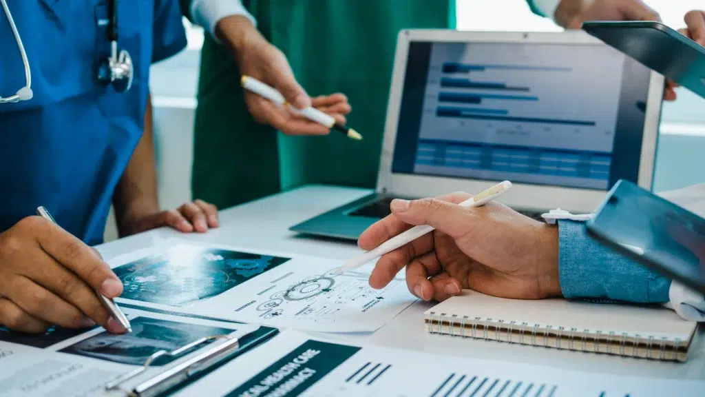 Healthcare executives reviewing RCM performance reports to evaluate a revenue cycle management company