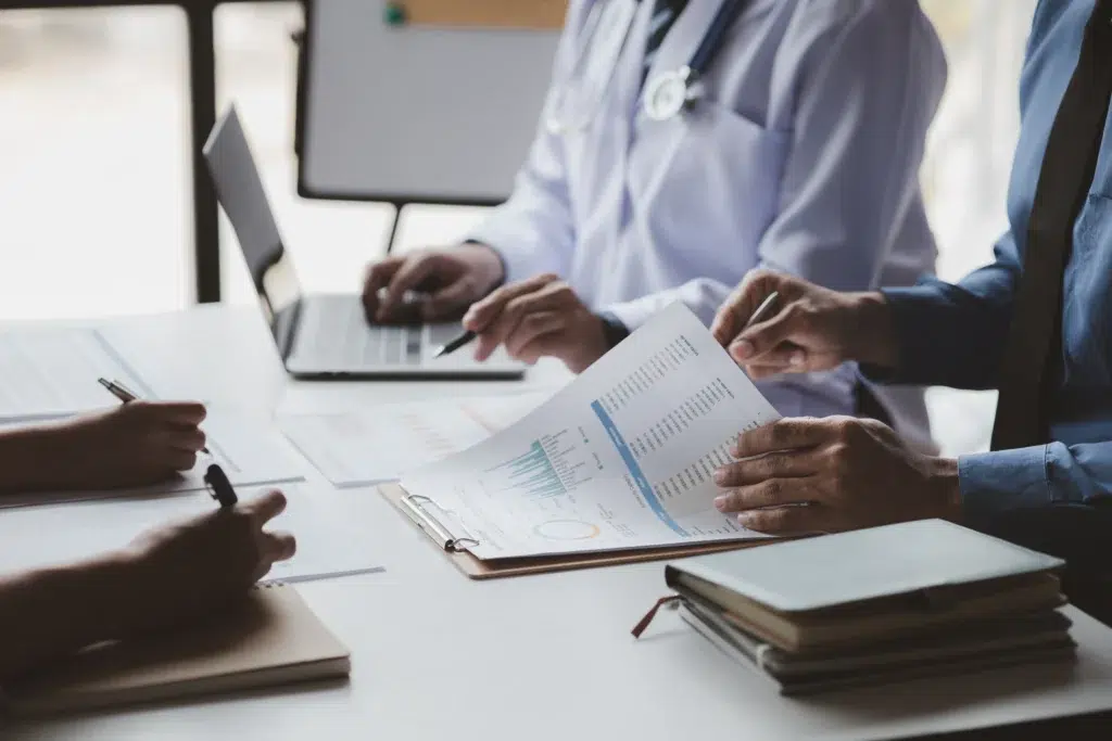 Healthcare executives reviewing RCM solutions in a hospital conference room
