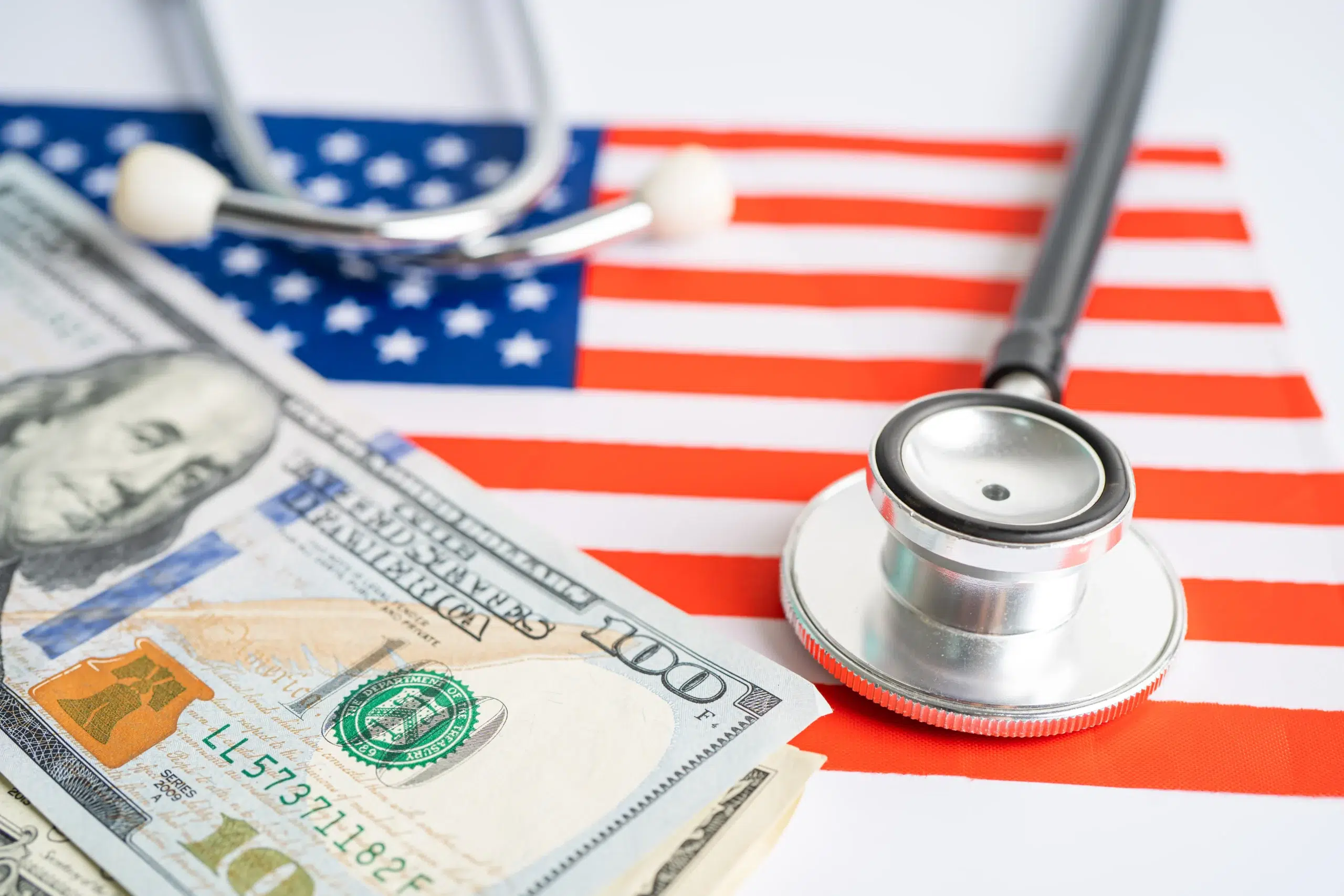 U.S. healthcare costs represented by stethoscope and dollars on American flag, highlighting the need for effective RCM solutions
