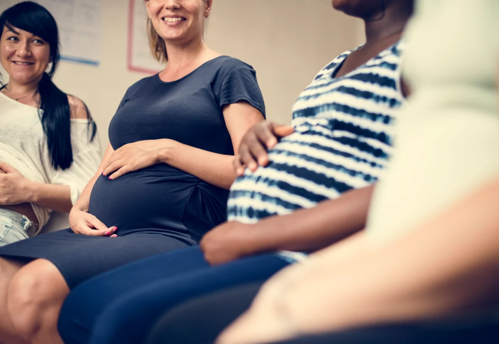 Pregnant women meeting indoors, representing antepartum and prenatal care reported separately under the 2027 maternity coding changes