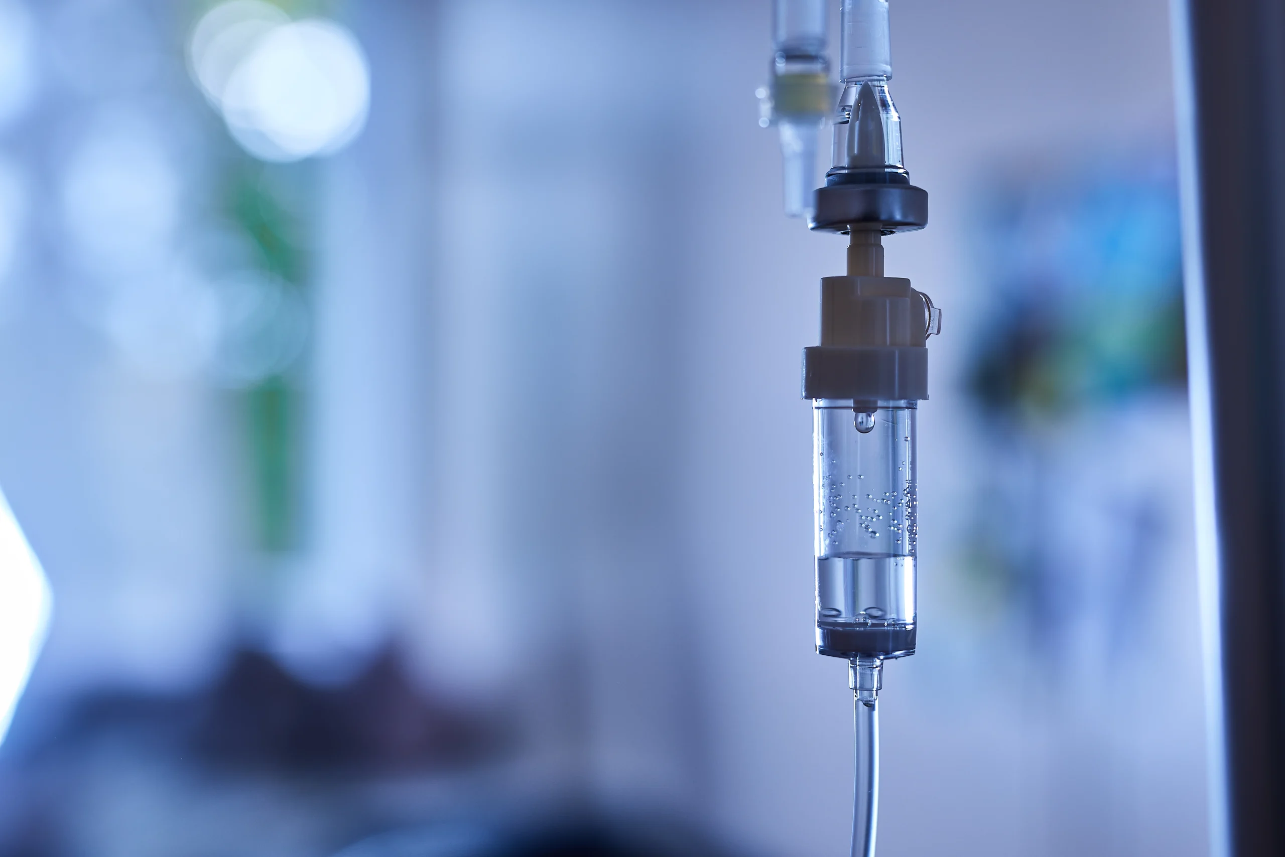 Intravenous infusion bag and line in a hospital room, representing IV infusion billing services and time-based CPT 96365 coding
