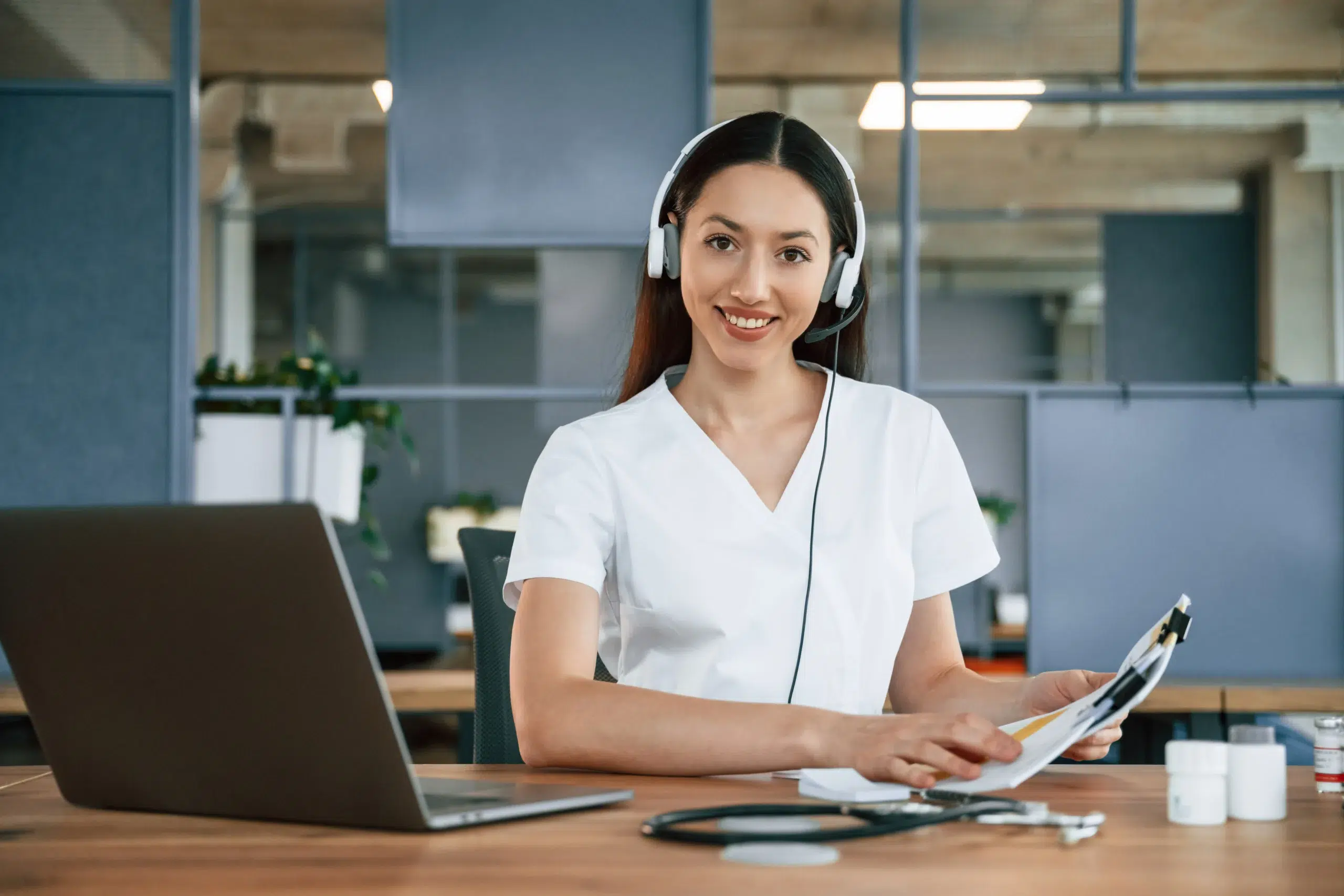 Billing specialist at a desk with a headset, representing acupuncture billing services that handle coding and claims for practices
