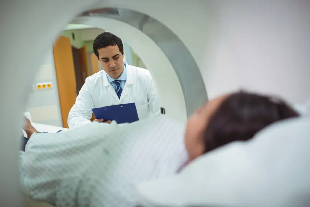 Physician overseeing a patient's CT scan, part of the treatment planning phase that oncology billing and coding reports separately