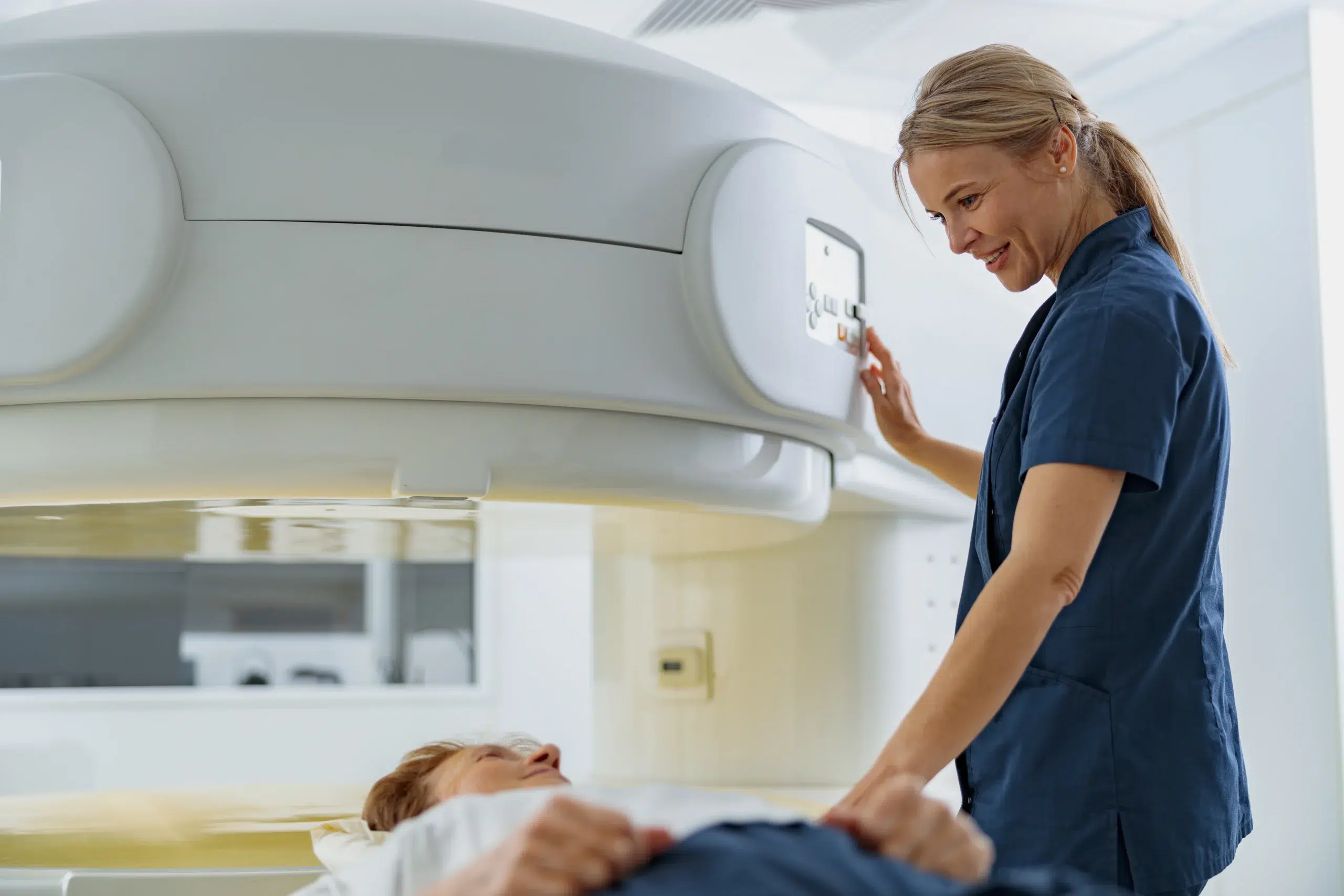 Clinician operating a scanning and treatment machine during a radiation therapy course billed through radiation oncology billing services