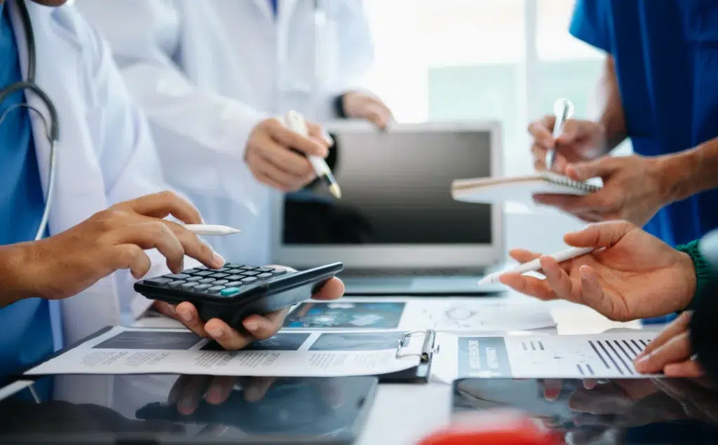 Medical team analyzing data and figures at a desk, the kind of review involved in reconciling electronic remittance advice files