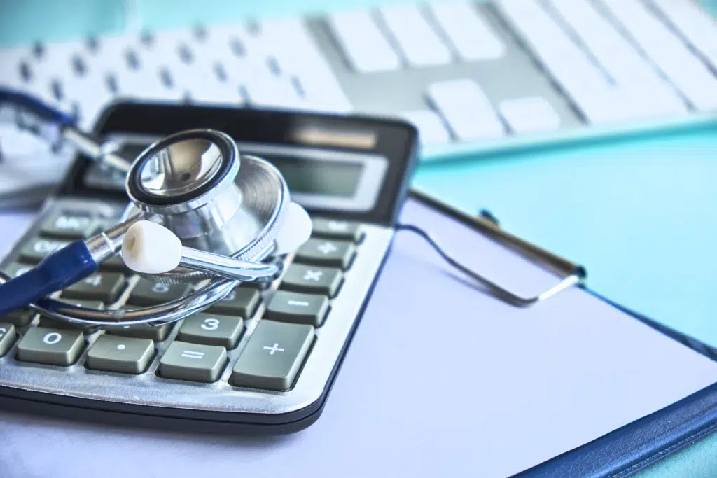 Stethoscope and calculator on a desk, representing the payment and adjustment amounts detailed in an electronic remittance advice
