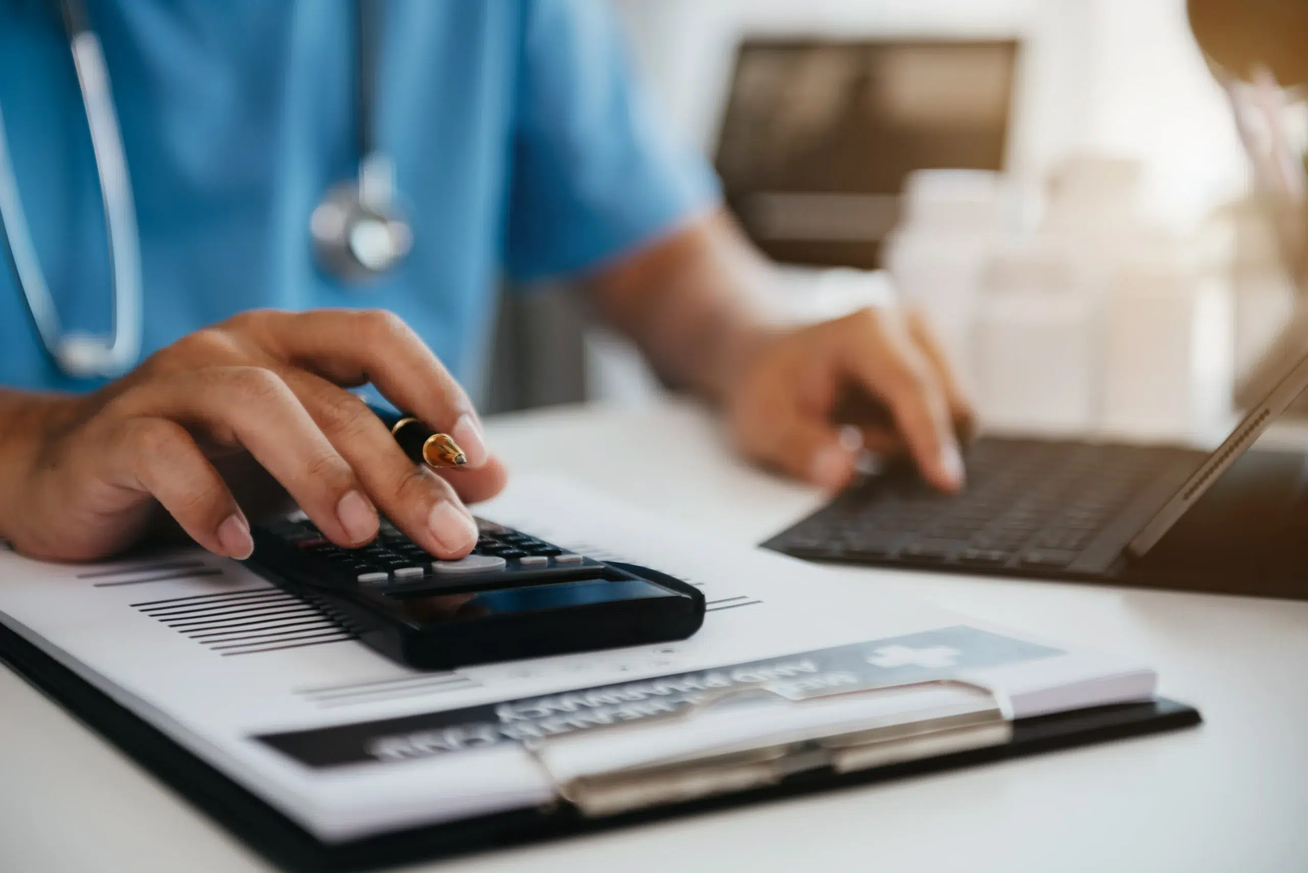 Healthcare professional using a calculator at a desk, representing CPT 96372 reimbursement and the drug units billed alongside the injection code