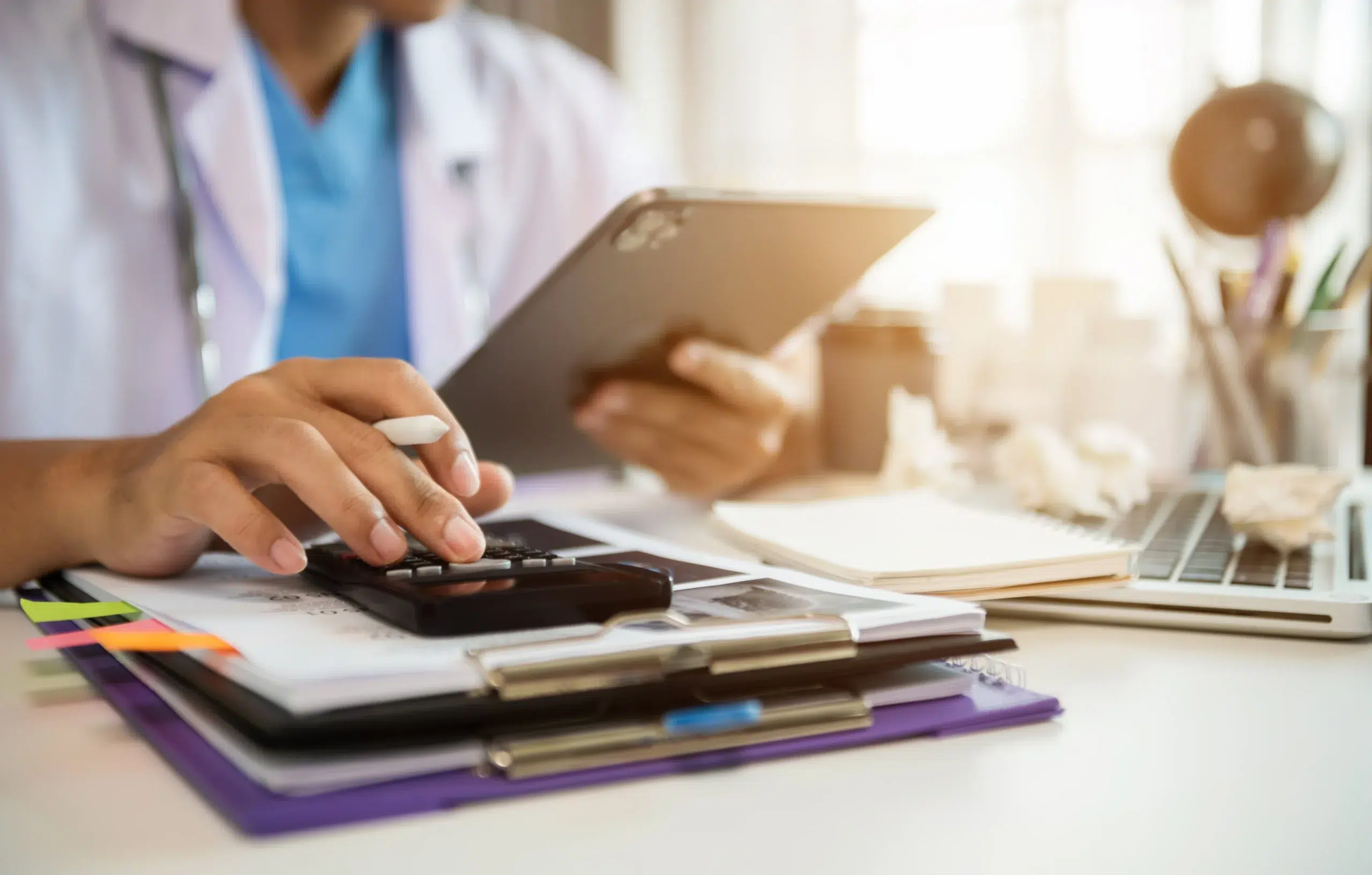 Healthcare professional working with billing data and a calculator, reflecting how an electronic remittance advice is used in payment posting