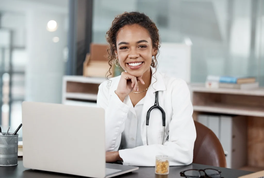 Provider at a desk with a laptop, documenting a patient encounter into a superbill that drives the billing process