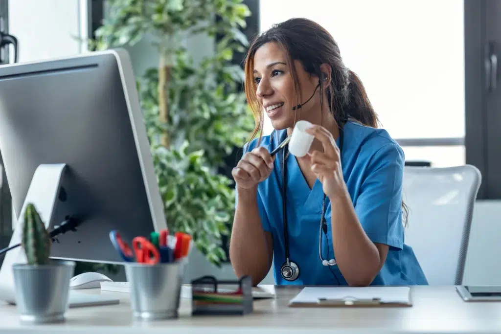 Healthcare professional at a computer reviewing a superbill, the first step in turning a patient visit into a clean claim